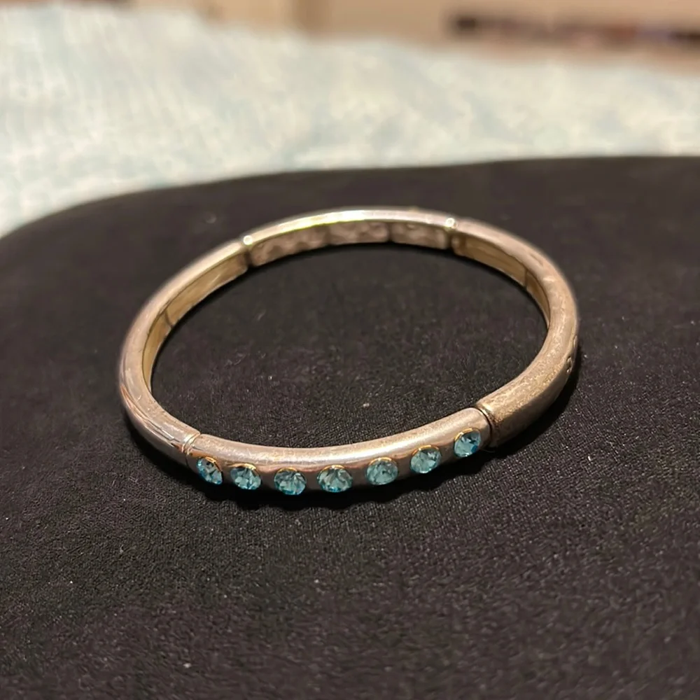 Kids silver bracelet with 7 blue rhinestones each side of bracelet. Gently used